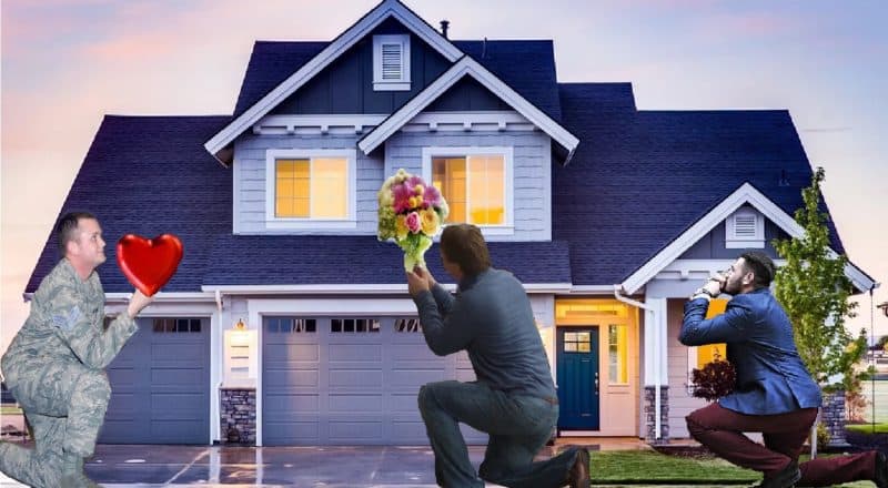 three men kneeling in front of a house, one holding a heart and the other is holding flowers